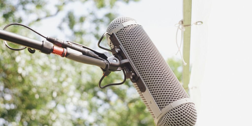 A microphone attached to a pole with trees in the background