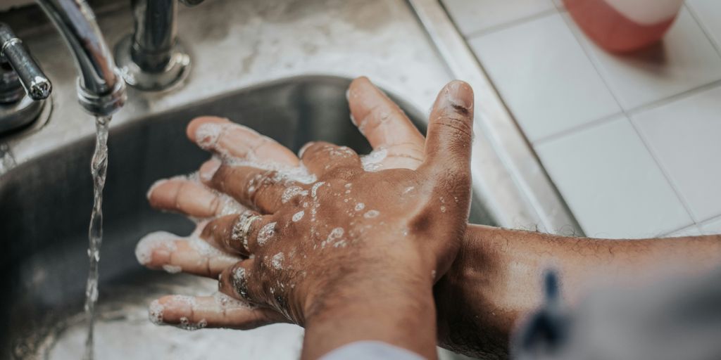 person in white shirt washing hands