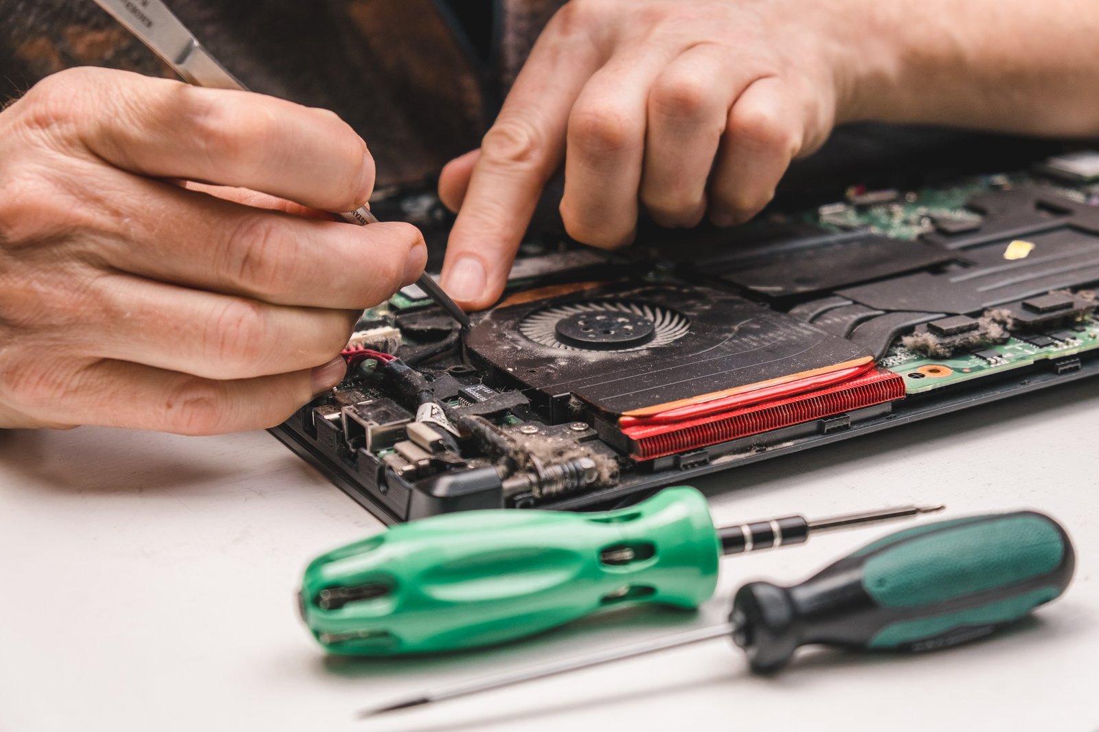 a computer repair specialist disassembles and cleans the laptop cooling system laptop maintenance