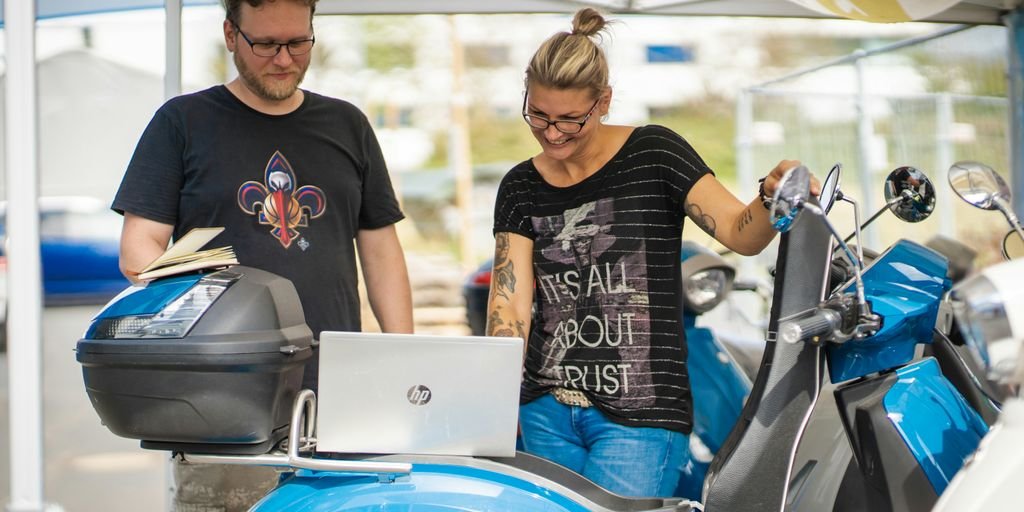 man in black crew neck shirt sitting on blue and silver motorcycle