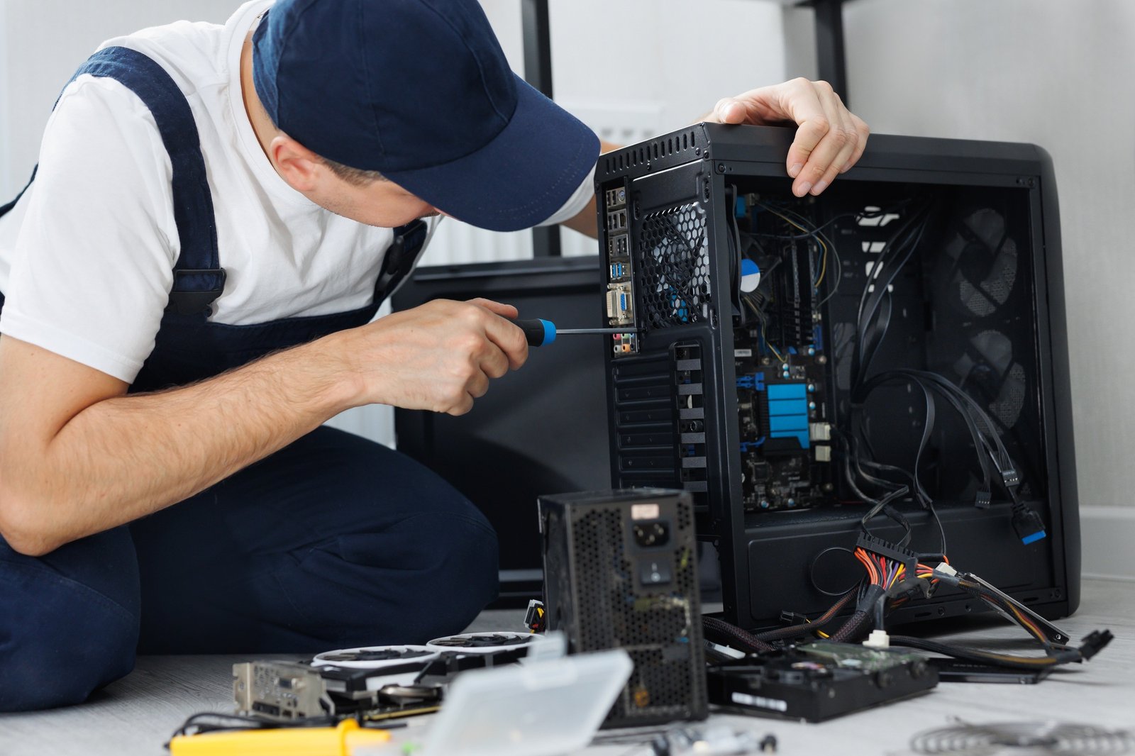 Closeup computer technician holding a screwdriver and repairing a pc.