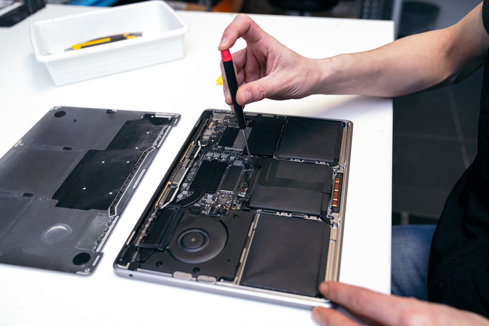 expert technician precisely dismantling laptop for repair