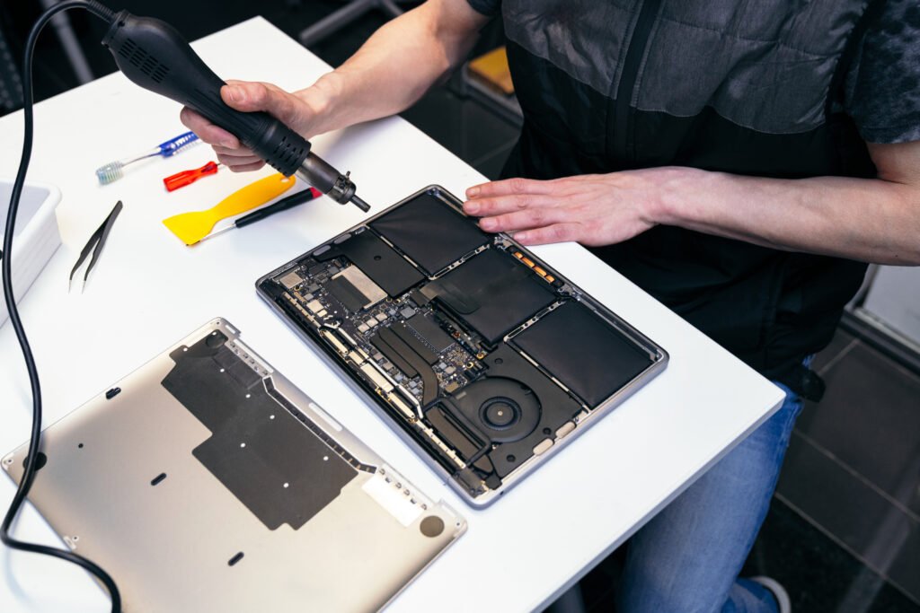 Your Go-To Apple Mac Repair Expert In Clacton Near You 3 Technician working on a laptop with heat gun and tools in Harwich